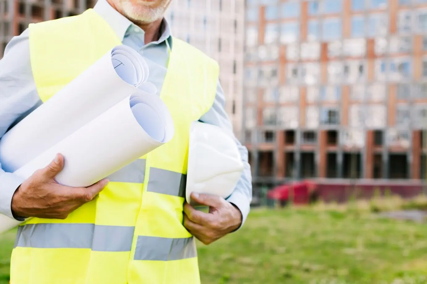 Крупный план мужчины в неоново‑жёлтом жилете и шлеме.